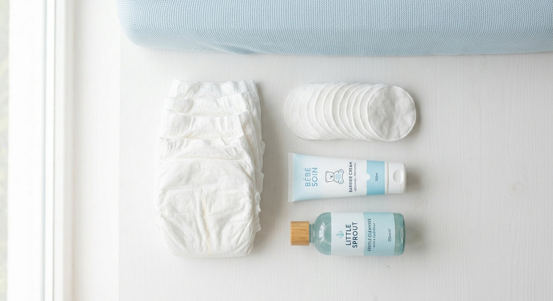 Produits de soin pour le change de bébé, crème protectrice et couches propres sur un plan à langer