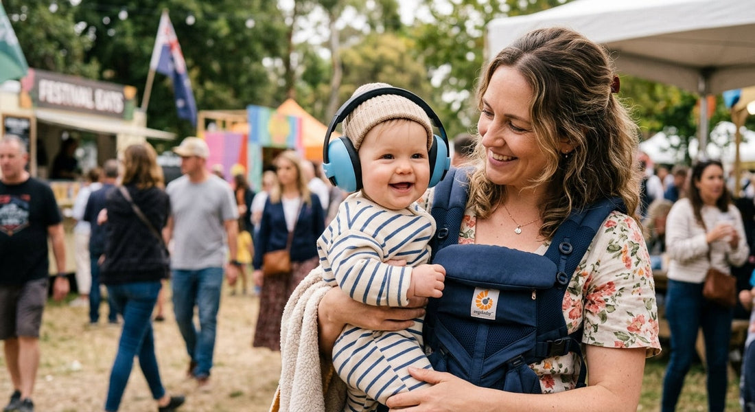 Mère et bébé souriants, l'enfant portant un casque anti-bruit, dans une foule animée en extérieur.