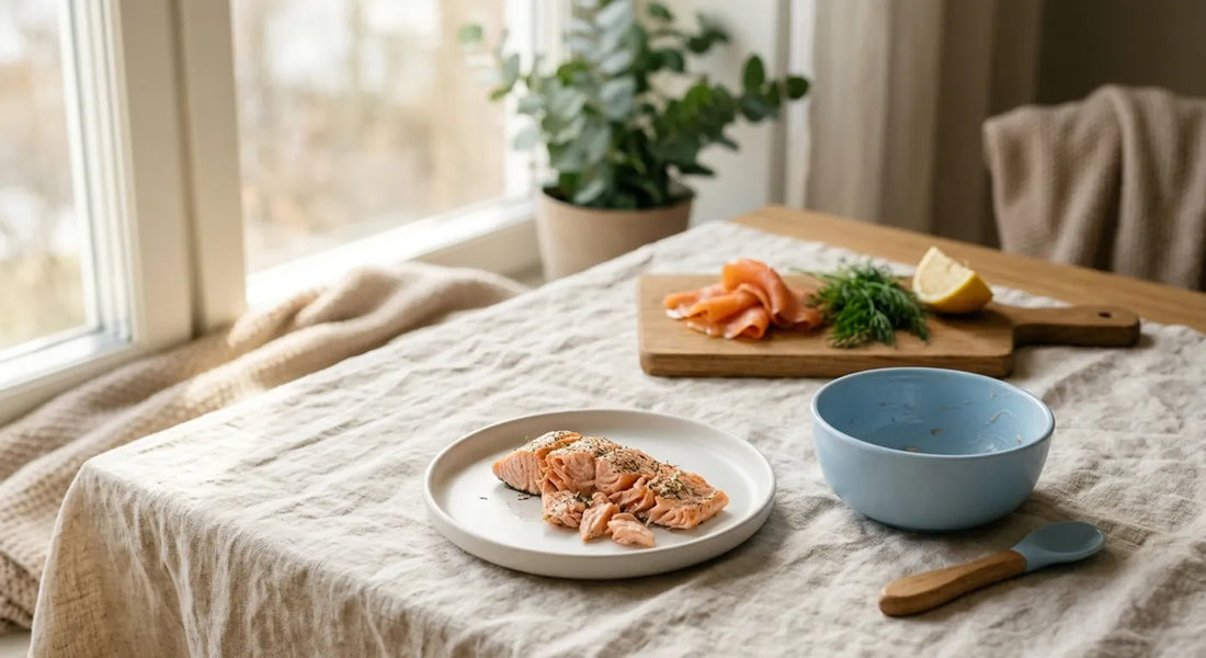 Saumon cuit émietté dans une assiette d'enfant, tranches de saumon fumé tenues à l'écart sur une planche