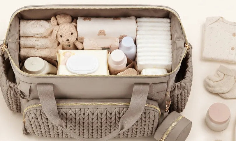 Grand compartiment du sac de maternité Securidou ouvert, rempli d’affaires de bébé