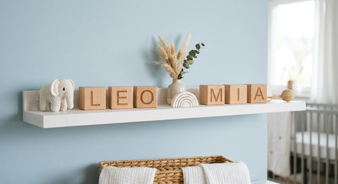 Lettres en bois formant des prenoms de bébé sur un mur