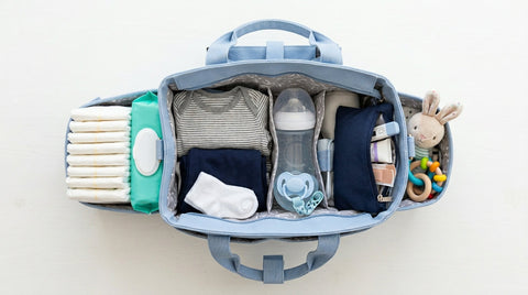 Sac à langer bleu pastel ouvert en vue du dessus avec essentiels bébé organisés : couches, lingettes, biberon, | Securidou