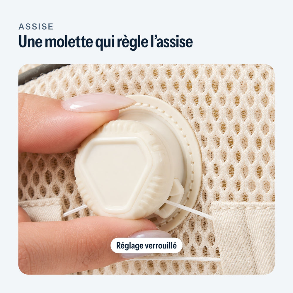 Doigts qui tournent la molette de réglage de l’assise du porte-bébé