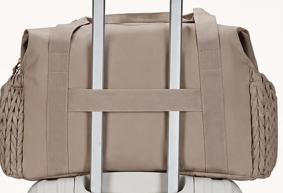 Passant arrière du sac de maternité Securidou glissé sur la poignée d’une valise